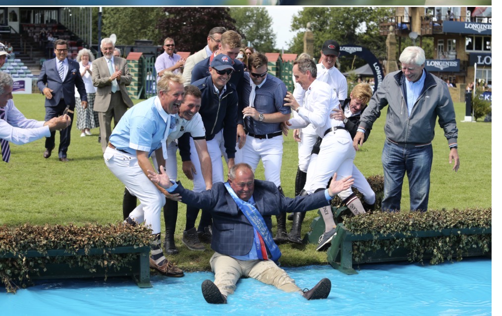 Bob Ellis celebrating with friends in the water jump at a major showjumping event
